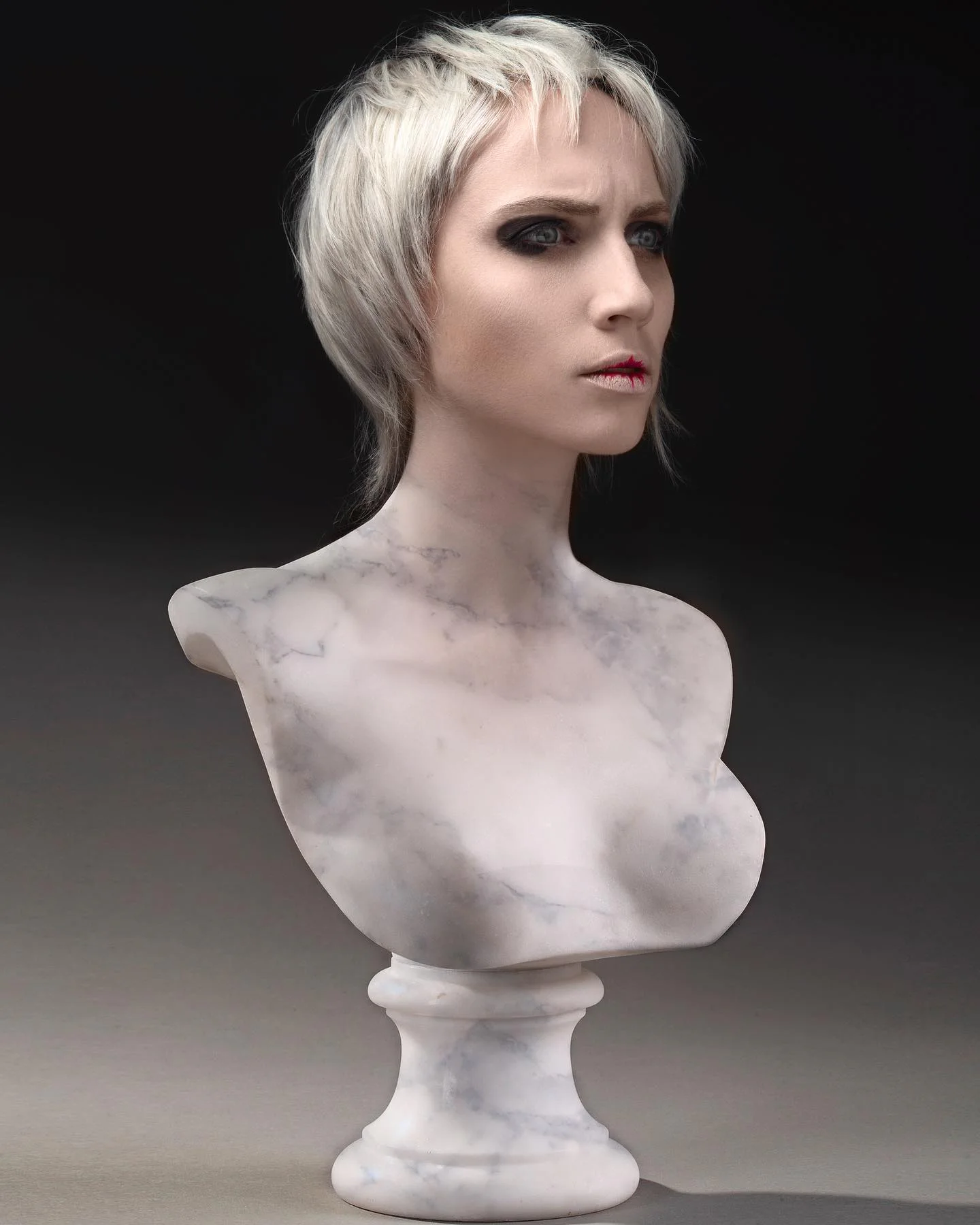 Coupe courte blond platine aux lignes graphiques sur un portrait sculptural