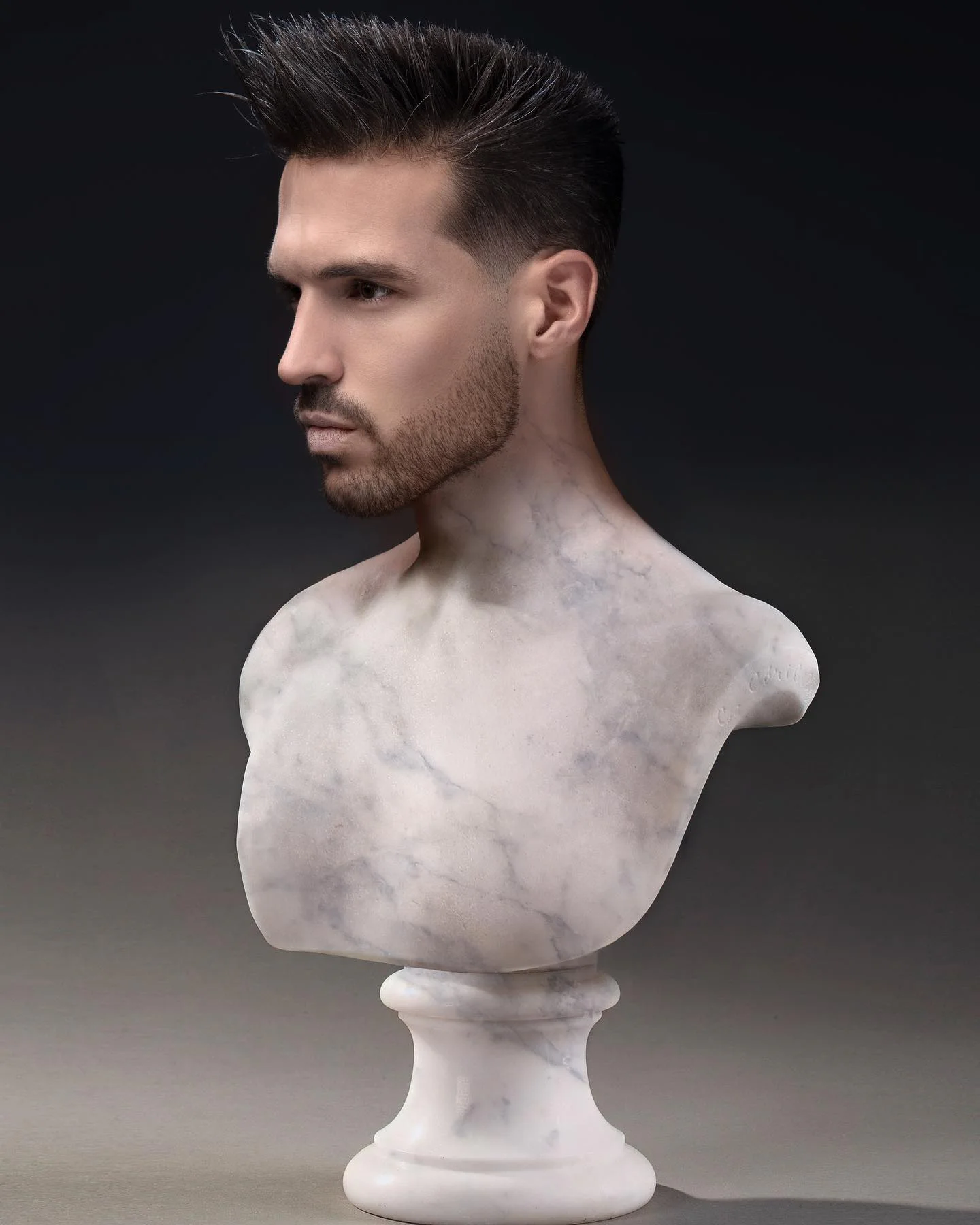 Coupe homme brune structurée avec contours précis sur un buste de marbre