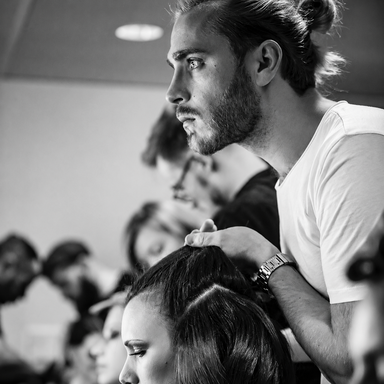 Portrait noir et blanc de Nicolas Goudeau au travail, observant une coiffure